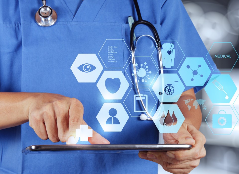 Clinician in scrubs using a tablet with medical icons